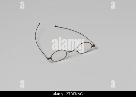 Glasses with narrow iron frame, oval lenses, double nose bridge and long  straight legs in a cigarette box, Glasses with narrow steel frame, oval  lenses and long straight legs. Double bow over