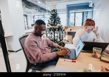 Colleagues working together on project in positive atmosphere. Multiracial colleagues working together with persistence and innovation. Stock Photo