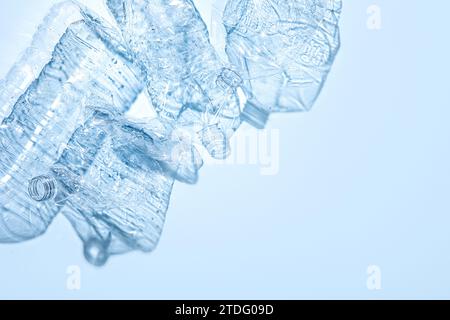 On a blue background, crushed plastic bottles are collected separately Stock Photo