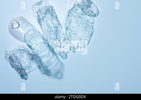 On a blue background, crushed plastic bottles are collected separately Stock Photo