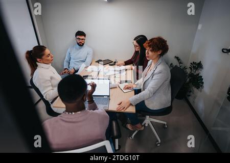 Diverse business team collaborating, analyzing statistics for market expansion and profit growth. Stock Photo