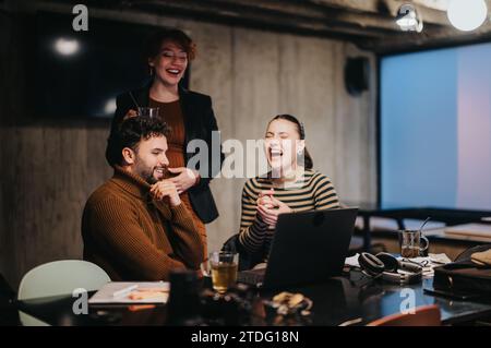 Business professionals analyzing sales statistics and discussing a marketing strategy for business growth in a corporate office late at night. Stock Photo