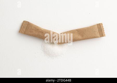 paper sticks of sugar, white sugar in paper kraft packaging, mock up for design isolated on white background with clipping path, top view Stock Photo