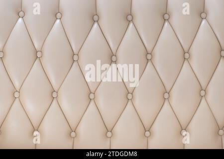 Elegant creamy beige leather upholstery texture with buttons for pattern or background Stock Photo