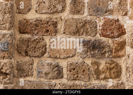 Closeup of rows of variegated, multi-colored stones forming the outer wall of a fortress in Acre, Israel. Stock Photo