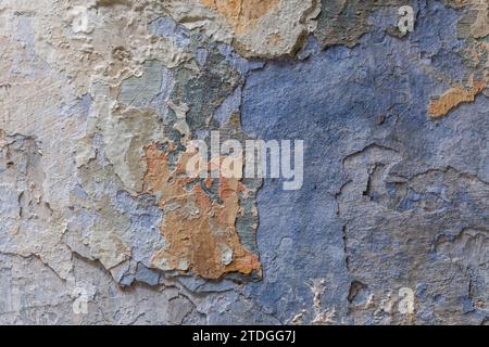 Abstract, detail, colorful pattern of multi-colored peeling paint layers on an old stone exterior wall of a building in Jerusalem, Israel. Stock Photo