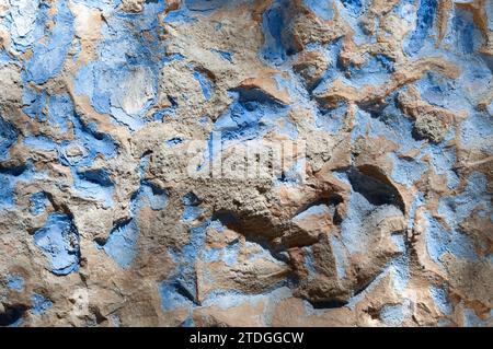 Abstract, detail, colorful pattern of blue paint on the rough surface of on an old stone exterior wall of a building in Jerusalem, Israel. Stock Photo