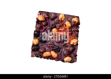 Handmade chocolate with berries, nuts and spices on a dark concrete background. Sweets made at home Stock Photo
