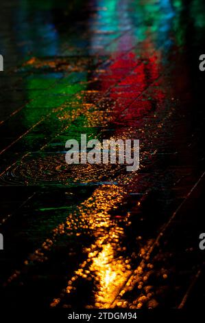 Abstract rendering of the slick pavement of Jaffa Road in downtown Jerusalem illuminated by bright, colorful artificial light on a rainy winter night Stock Photo