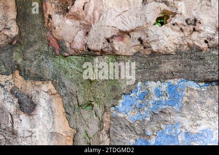 Abstract detail closeup of a stone wall with peeling and cracked blue and green paint and grouting on an old building in Jerusalem, Israel. Stock Photo