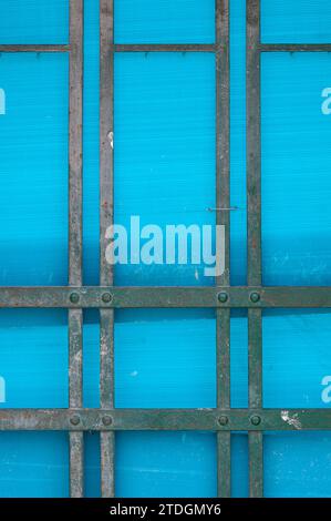 Abstract rendering of metal bars, lines and blue plastic material covering a door. Stock Photo