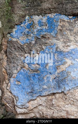 Abstract detail closeup of a stone wall with peeling and cracked blue and green paint and grouting on an old building in Jerusalem, Israel. Stock Photo