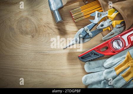 Set of construction tooling in leather tool belt on wooden board Stock Photo