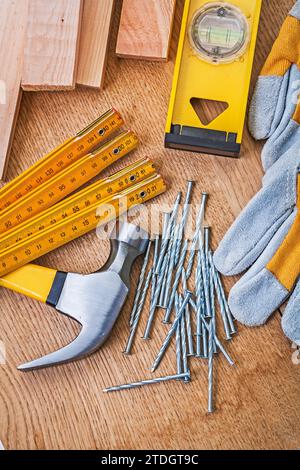 Carpenter's tools Nails Claw hammer Protective gloves Aligning boards on wooden plank Stock Photo