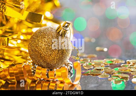 Gold coloured christmas ball with string on background of bokeh horizontal version Stock Photo