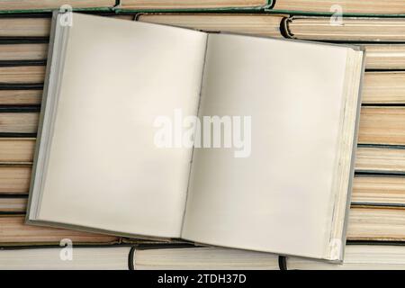 Opened old book with blank pages on a stack of paper books Stock Photo