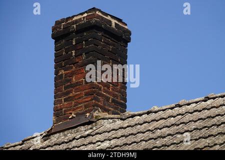 brick chimney on tile roof Stock Photo