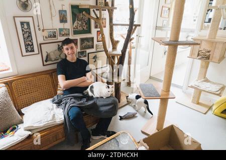 A family enjoy their time in an unusual cat cafe surrounded by cats. Stock Photo