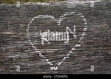 K + N written inside a heart, drawn in white chalk on a weathered wooden surface Stock Photo