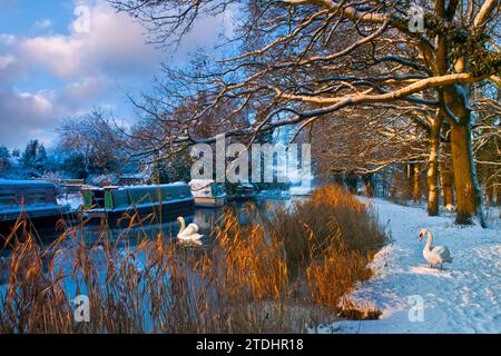 RIVER WEY WINTER SNOW SURREY View upstream at Send/Ripley with snow laden towpath swans and moored boats in winter at dawn sunrise. Surrey UK Stock Photo