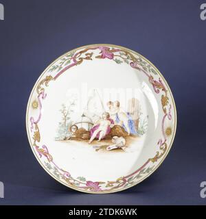 Dish, cup and saucer, anonymous, c. 1750 - c. 1774 Porcelain dish, painted on the glaze in blue, red, pink, green, yellow, brown, black and gold. On the flat of the dish a symbolic representation with three putti, one of which blows through a pipe; Behind them a wicker basket, pyramid, skull, mask, crown, globe, books and other objects; The edge with a tire leaf vines, ribbons, branches and two radiant suns with a face. Presentation to a drawing by Jacob de Wit (1695-1754), 'Allegory of transience'. Wand has been broken. European performance in email colors. Chinaafter print by: Amsterdam porc Stock Photo