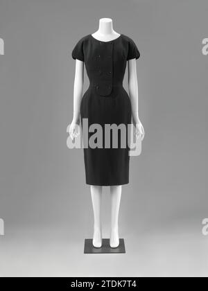 Dress and Jacket (Complet), Catharina Kruysveldt-de Mare, c. 1952 Black wool dress with cut short sleeve, transshipment to the left with double row of black buttons, pencil skirt and narrow belt. Model: Round neck, short sleeves, pencil skirt. Narrow belt that runs from the side seams to the back and closes in the middle with a knot. Counterfeit transfer to the left over the body. Three coupling councils on either side. Transshipment runs down the taillen council in the middle; The Taillaad follows this line. Closure in the middle behind metal zipper. Split with bell jersey folds in the middle Stock Photo
