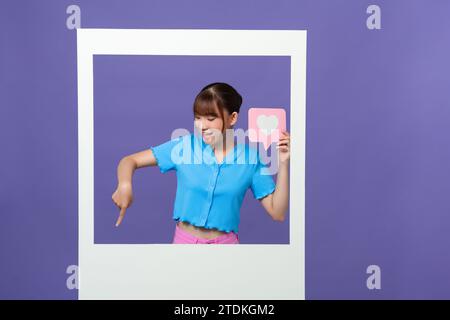 Photo of sweet impressed lady tacking photo getting likes isolated on violet background Stock Photo