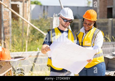 Professional construction workers engineer man working with women team. Real estate house project builder teamwork. Smart architect people standing wo Stock Photo