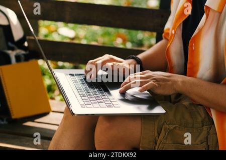 Cropped image of young man working on laptop in city park Stock Photo
