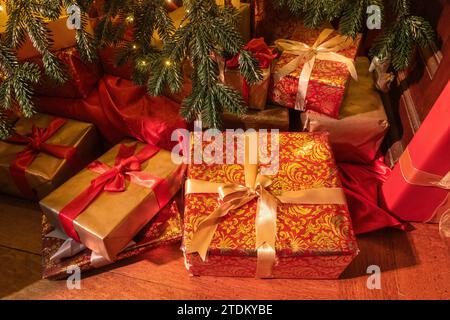 Christmas presents or gifts under the Christmas tree wrapped in colourful wrapping paper with ribbons Stock Photo