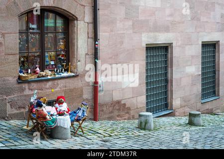 Doll store in the old town of Nuremberg. The owner has decorated the sidewalk in front of the store with dolls. Stock Photo