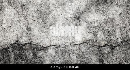 Fractured concrete wall or floor. Damaged wall background. Gray grunge cement surface with large cracks. Stock Photo