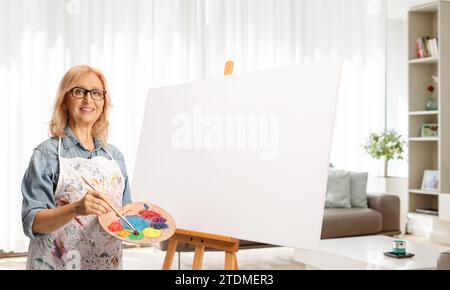 Woman with a blank canvas standing in a living room Stock Photo