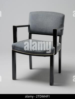 Arm chair with angular armrests and covered with blue Trijp, Jacobus Fernandus Adolphus Semey, 1933 Arm chair of black lacquered wood resting on four square legs. The front legs are straight and the hind legs are slightly bent and continue in the backstyles. The session is set in four lines whose two side rules are right and the front and back rule bent. The benchmark of the backrest is also bent. From the center of the backrest, flat angular armrests walk off who are on the front, not in line with the front legs, on flat struts that are partly attached to the seat and partly. Both the handrai Stock Photo