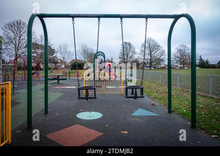 Swings designed for young children and toddlers in the playground at the Recreation Ground in Old Windsor, Berkshire, UK Stock Photo