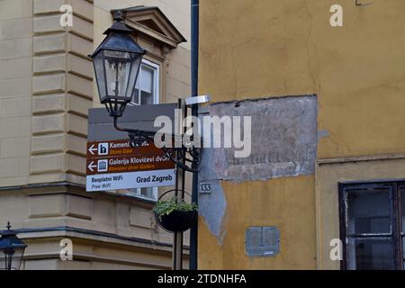 Tourist street direction signs and a ghost sign on the wall in the old town of Zagreb, Croatia Stock Photo