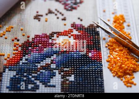 Process of creation beauty diamond painting 3d from square rhinestones, handmade hobby for rest. Focus on center Stock Photo