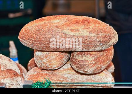 Bread, selection of freshly baked bread in baskets ready for sale on local produce farmers market stall. Bloomer Stock Photo