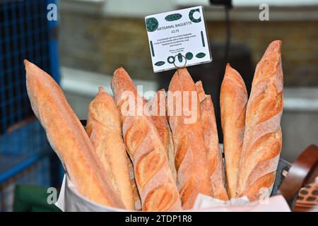 Bread, selection of freshly baked bread in baskets ready for sale on local produce farmers market stall. Baguettes Stock Photo