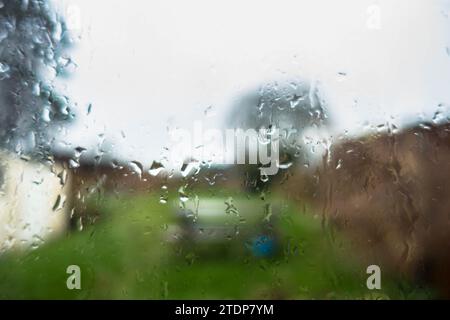 Water droplets on a window with an out of focus garden beyond Stock Photo