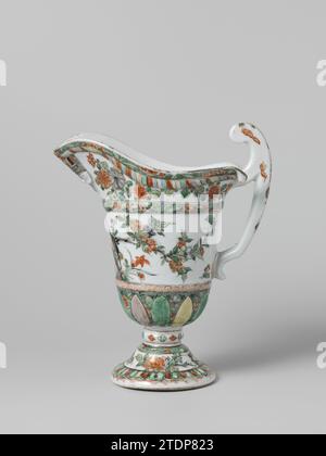 Helmet-shaped ewer with a face, animals and flower sprays, anonymous, c. 1700 - c. 1724 Helmet -shaped can on the foot of porcelain, berchilded on the glaze in blue, red, green, yellow, eggplant, black and gold. On the wall a wide band with flowering plants with a bird and two butterflies, below and above a decorative band; Around the foot a band with lotus leaves between which flower branches against a green speckled soil; Chrysanthemas branches on either side of the spout; The edge with a colored band and one with flower branches against a speckled soil. On the spout a face with headgear in Stock Photo