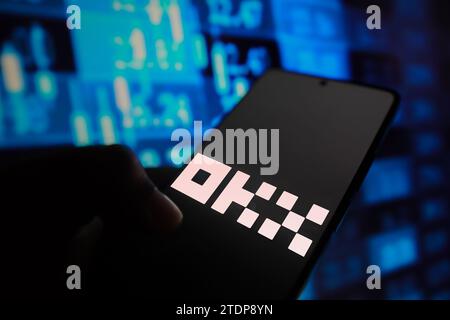 In this photo illustration, the OKX logo is displayed on a smartphone screen with stock market percentages in the background. (Photo by Rafael Henrique / SOPA Images/Sipa USA) *** Strictly for editorial news purposes only *** Stock Photo