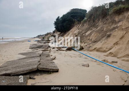 November 26th 2023.  Beach erosion at Hemsby in Norfolk with large sections of road on the Marrams being lost following recent storms.  Exposed water and power mains make beach access hazardous and five bungalows were condemned for demolition. With every storm and tidal surge a larger residential area made up of more expensive bricks and mortar homes drawS closer to the edge.  More sea defence work extending an existing rock berm will not now be happening, Hemsby ‘not qualifying’ for government funding. Stock Photo