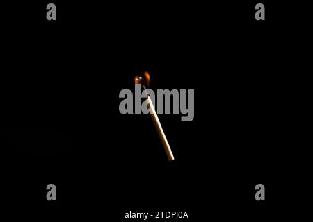 Lit and falling match on a black background. Stock Photo