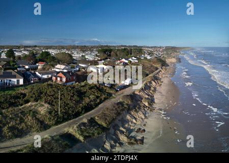 November 28th 2023.  Beach erosion at Hemsby in Norfolk with exposed water and power mains and large sections of road on the Marrams being lost.  Five bungalows have subsequently were subsequently been condemned for demolition. Stock Photo
