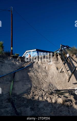 November 28th 2023.  Beach erosion at Hemsby in Norfolk with exposed water and power mains and large sections of road on the Marrams being lost.  Five bungalows have subsequently were subsequently been condemned for demolition. Stock Photo