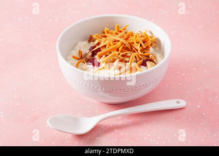 rice pudding with Norwegian brunost traditional brown cheese and raspberry jam Stock Photo