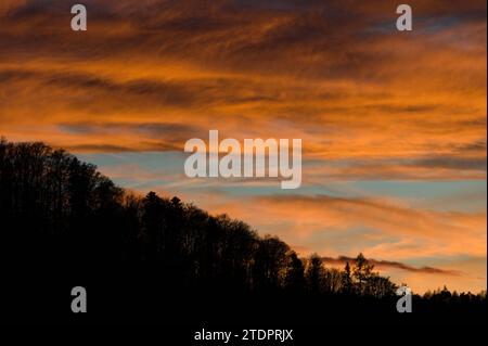 Forest on the hill and sunset on the background. Landscape of Czech republic nature. Dramatic colorful sky. Stock Photo