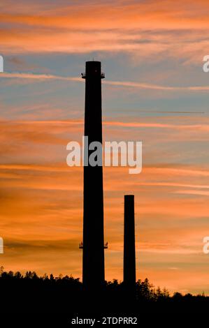 High old smokestack in industrial area and sunset on the background in Roznov pod Radhostem, Czech republic. Stock Photo
