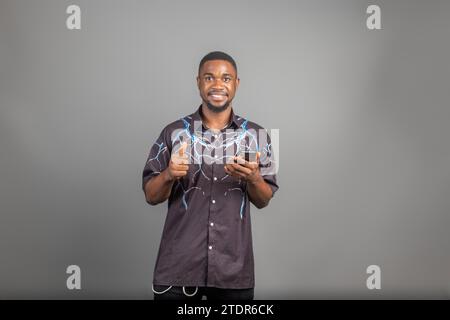 excited guy using in phone isolated over grey background Stock Photo